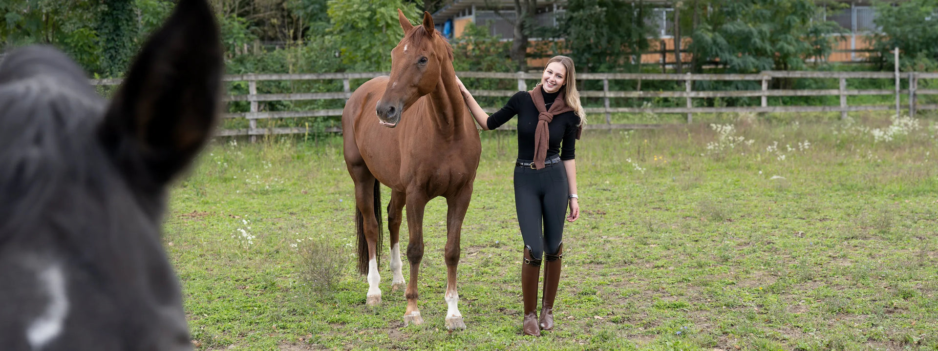 Girl standing in a field wearing classy equestrians riding tights jahalne pajkice oprema